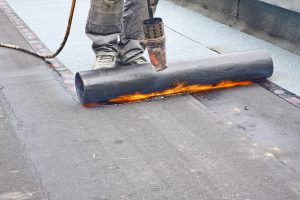 professional roofer using tools to repair roof