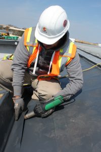 Curtis Construction worker installing roofing system
